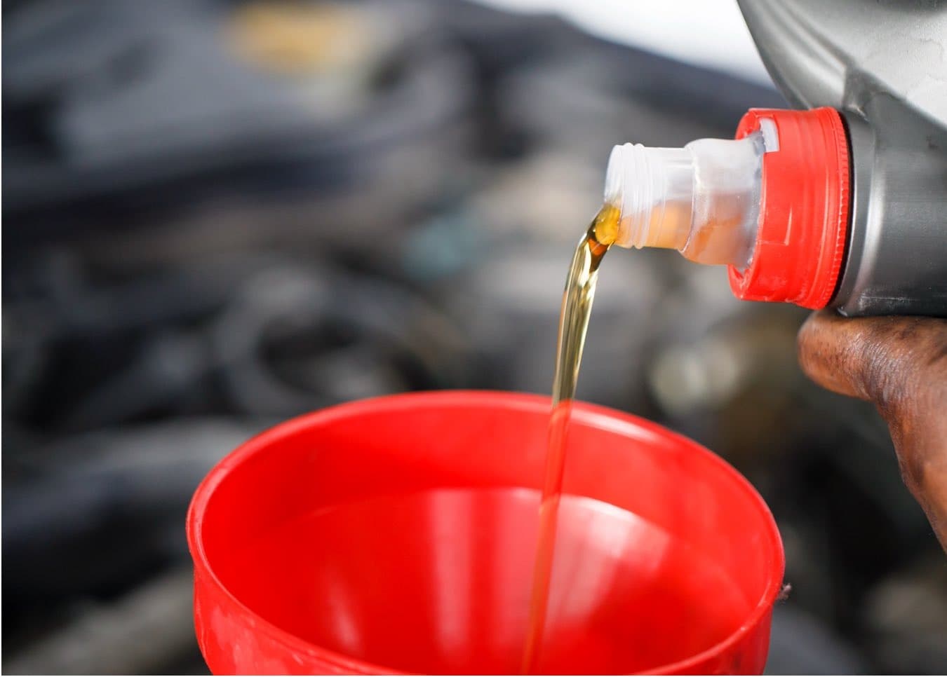 Fresh engine oil being poured during vehicle maintenance